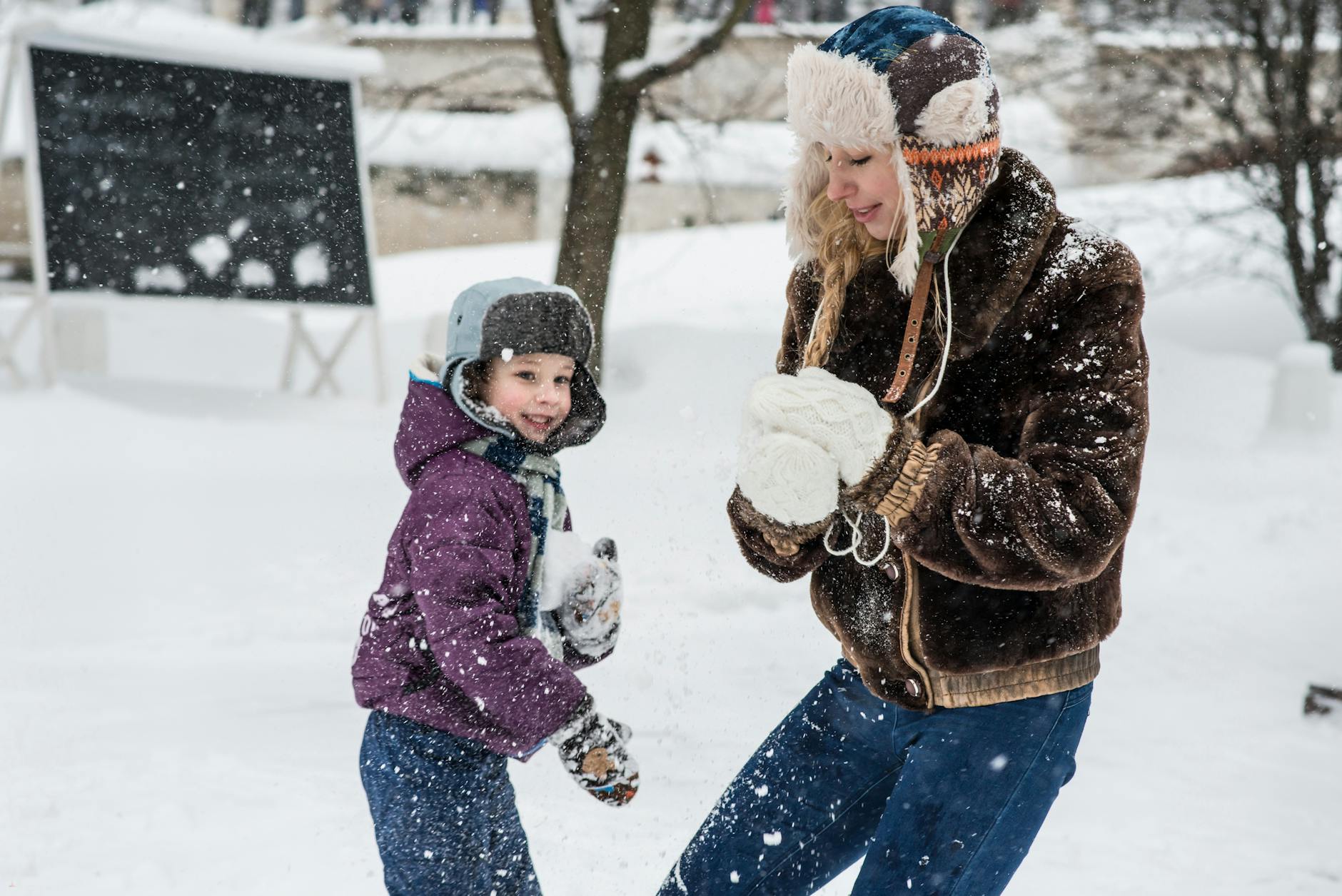 woman and child playing in snow